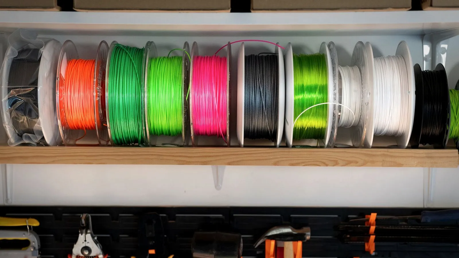 Shelf of colorful filament spools above a wall of pliers, cutters and hand tools