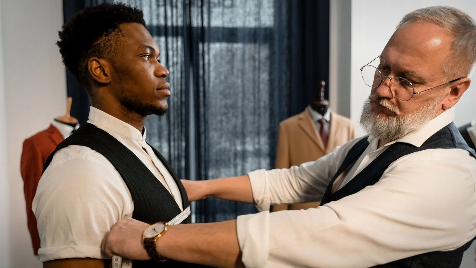 Tailor measuring a man’s shoulder and arm with a tape measure
