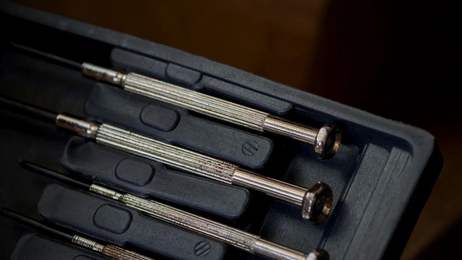 Set of precision screwdrivers lying in a black storage case