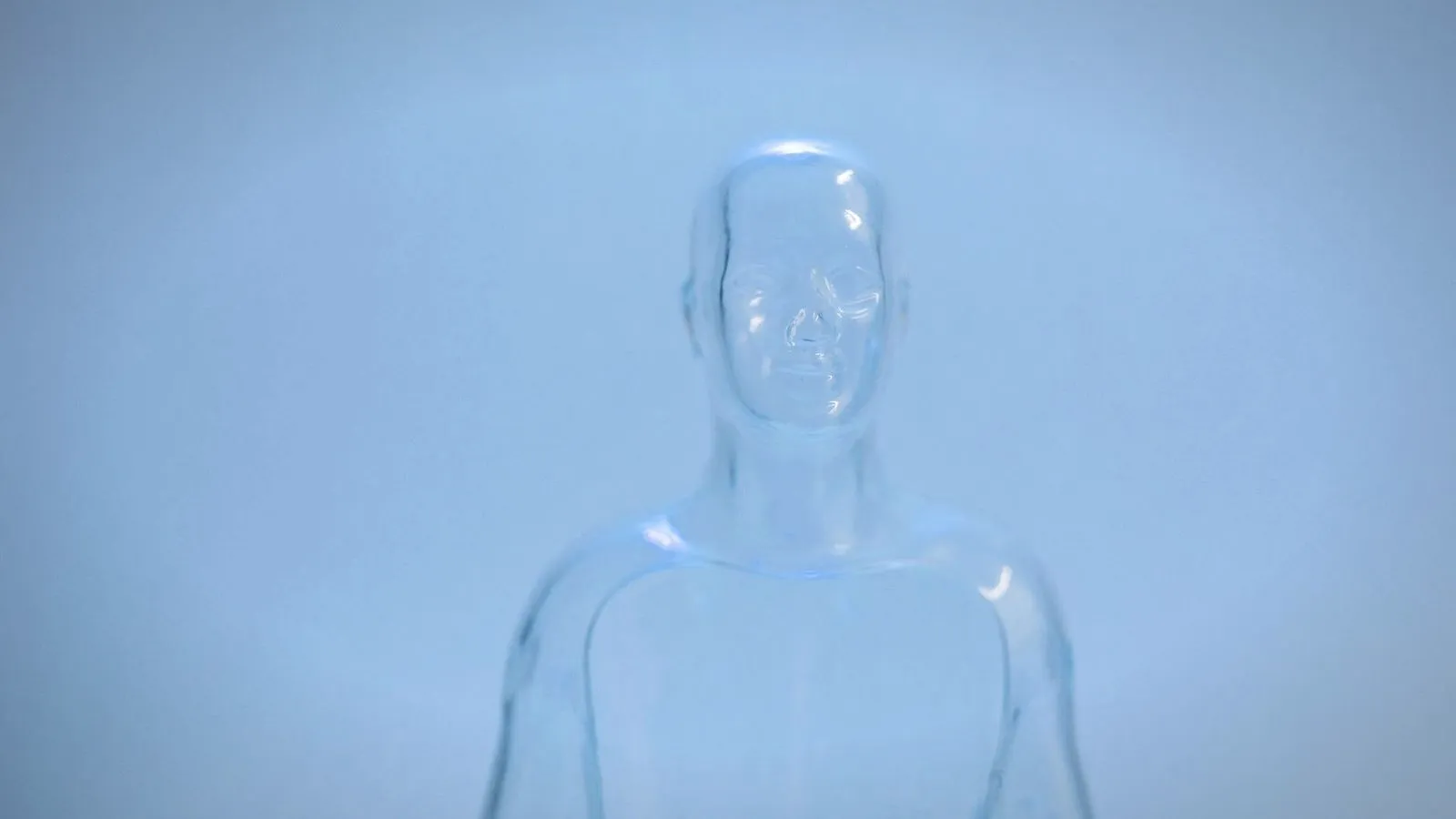 Transparent clear plastic figure of a human head and torso against a pale blue background